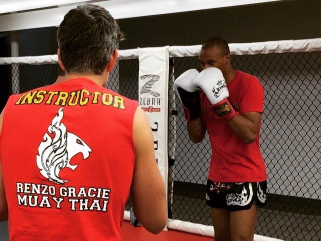 Alex Turner's intense combat sports photograph capturing boxer mid-punch with dramatic arena lighting and crowd energy