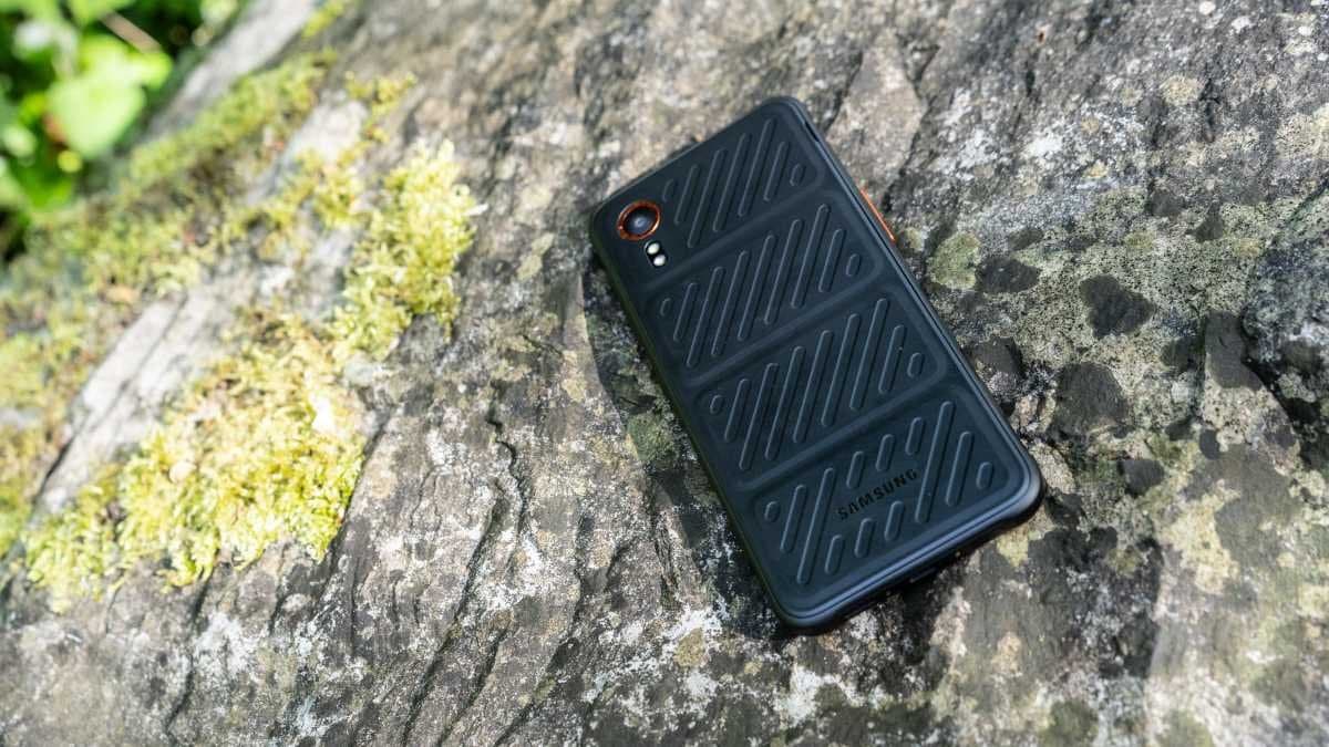 Samsung Galaxy XCover7 in its protective case showing the removable battery compartment and reinforced ports