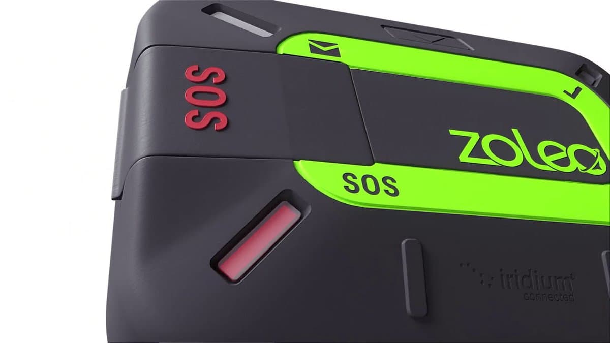 ZOLEO device next to smartphone showing app interface on wooden camp table